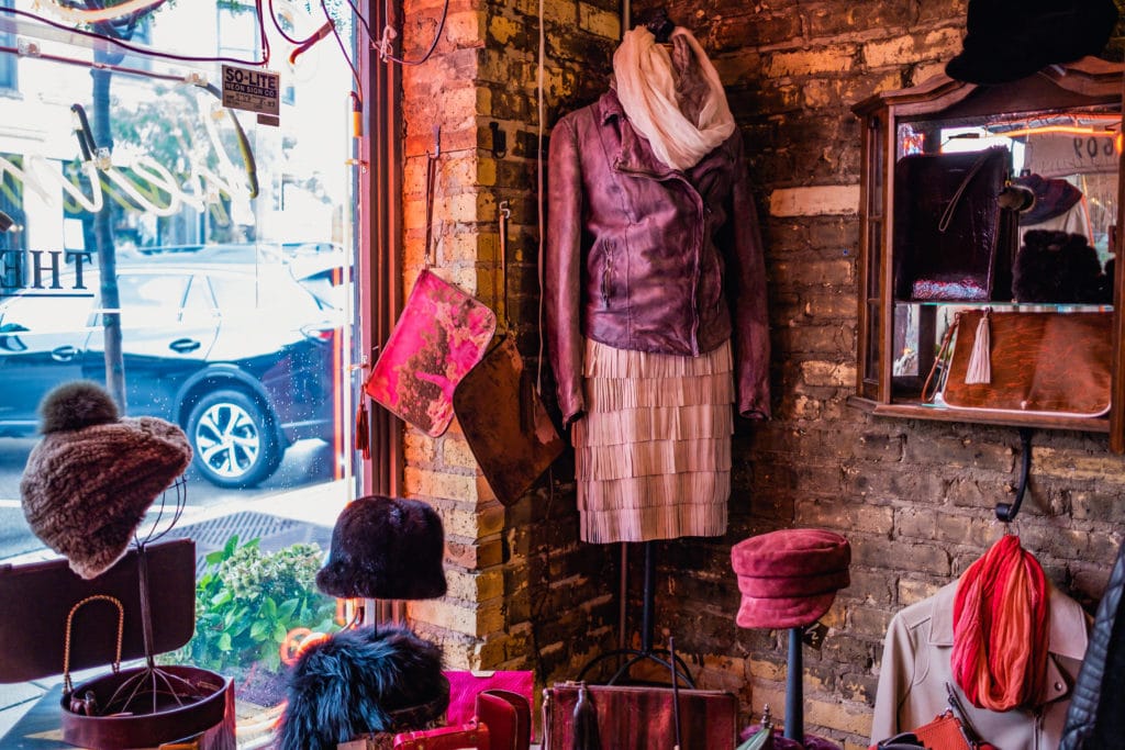 A full leather outfit and hats on display inside of Heinsight Leather in Wauwatosa