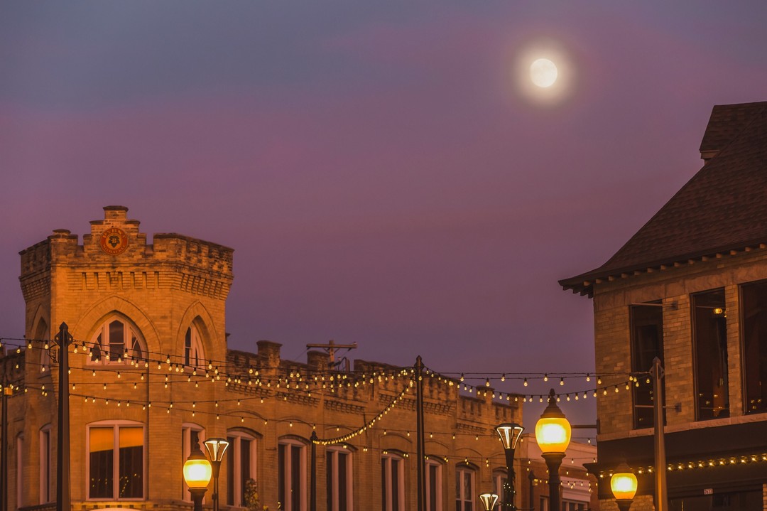 Evening sky over Tosa Village with historic architecture and string lights.