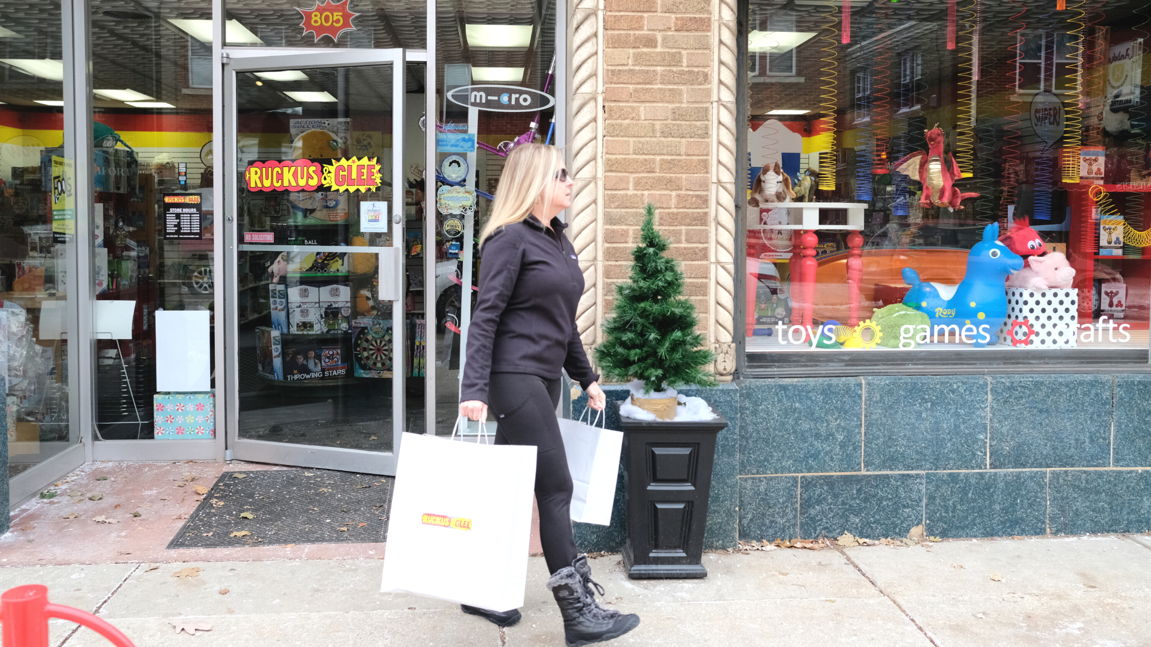 Woman walking out of Ruckus & Glee holding shopping bags in Wauwatosa, WI