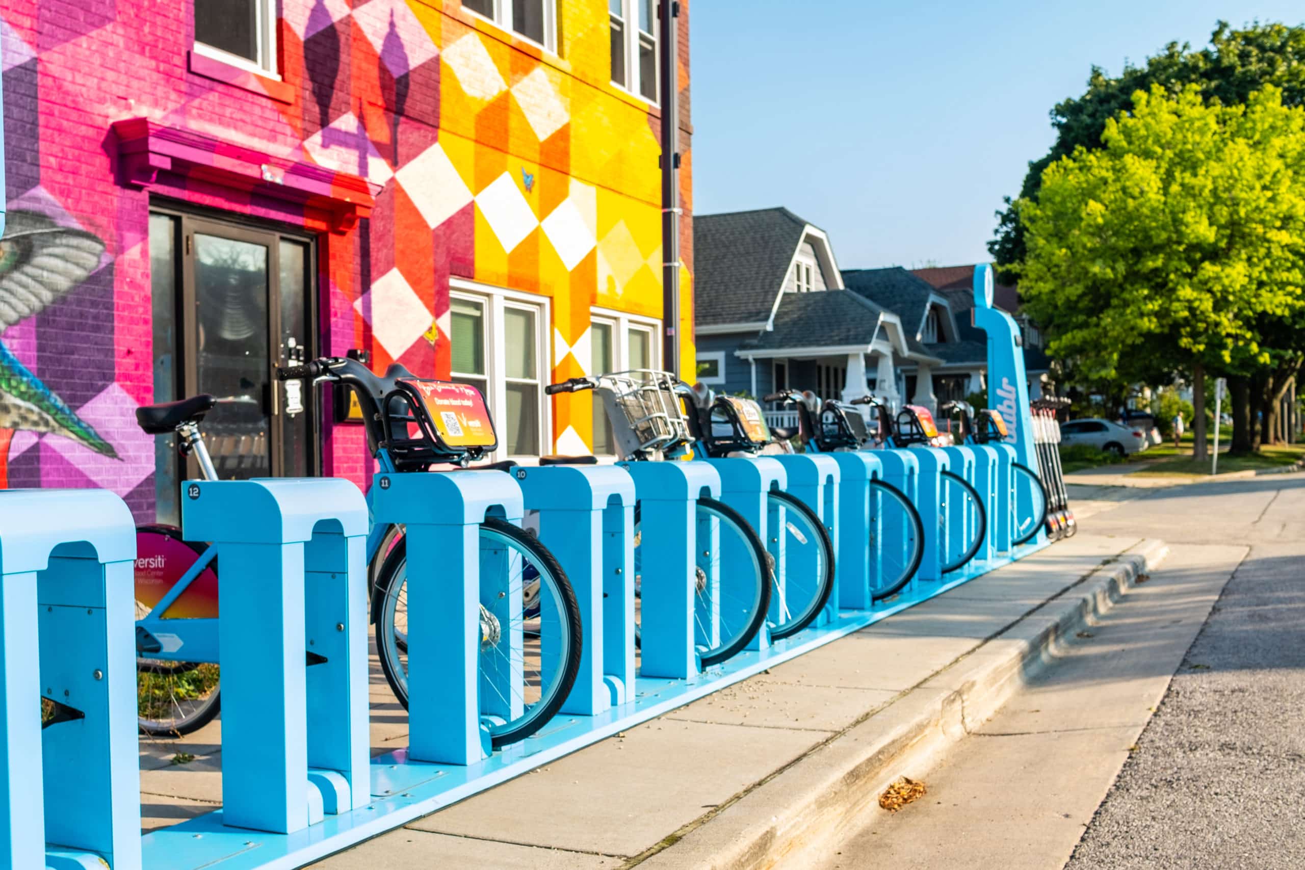 Colorful mural background with Bublr Bikes at their station.